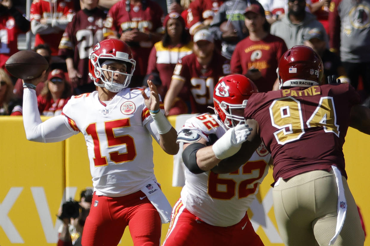 Oct 17, 2021; Landover, Maryland, USA; Kansas City Chiefs quarterback Patrick Mahomes (15) passes the ball under pressure form Washington Football Team defensive tackle Daron Payne (94) during the first quarter at FedExField. Mandatory Credit: Geoff Burke-USA TODAY Sports