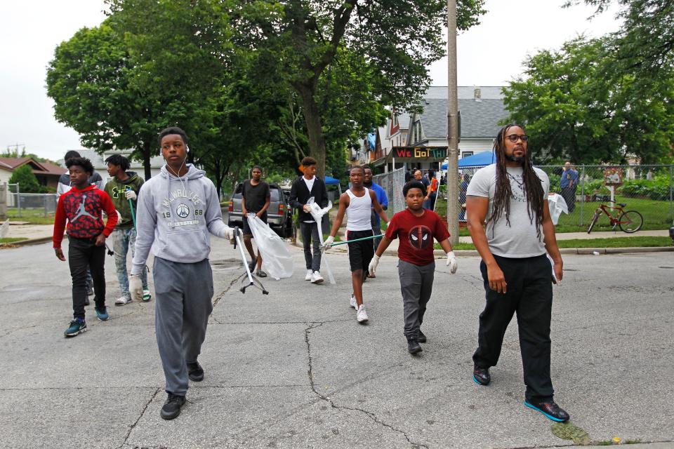 James Causey, right, leads a group of teens as they prepare to clean neighborhood streets near the "We Got This" garden in July while reporting on trauma in the 53206 Zip Code. The teens spend 10 weeks learning skills on gardening and life lessons from mentors. At the end of each four hour day on Saturdays, they are each paid $20.