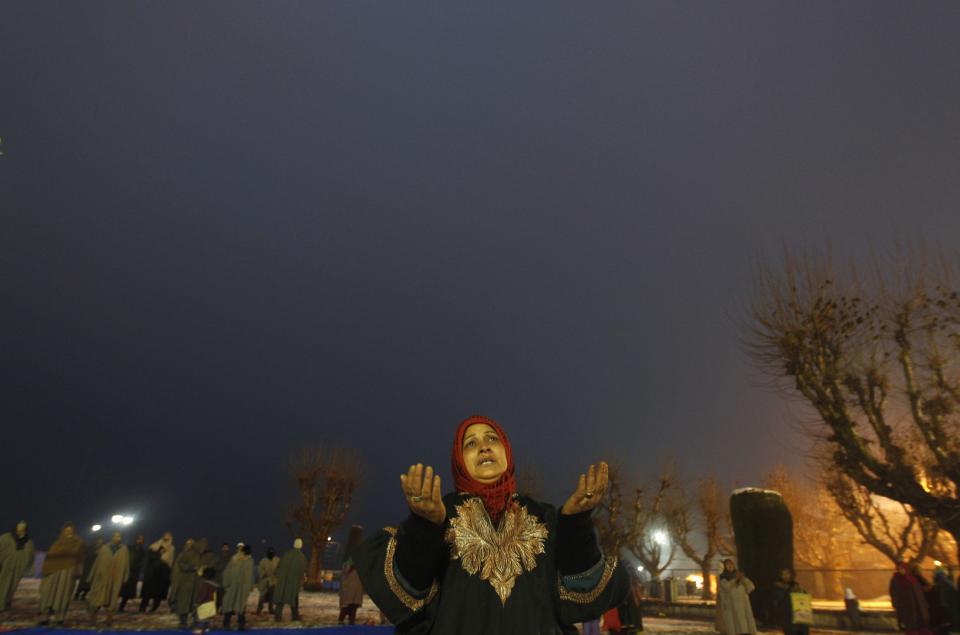 A Kashmiri Muslim woman prays during the festival of Eid-e-Milad-ul-Nabi at Hazratbal shrine on a cold winter morning in Srinagar