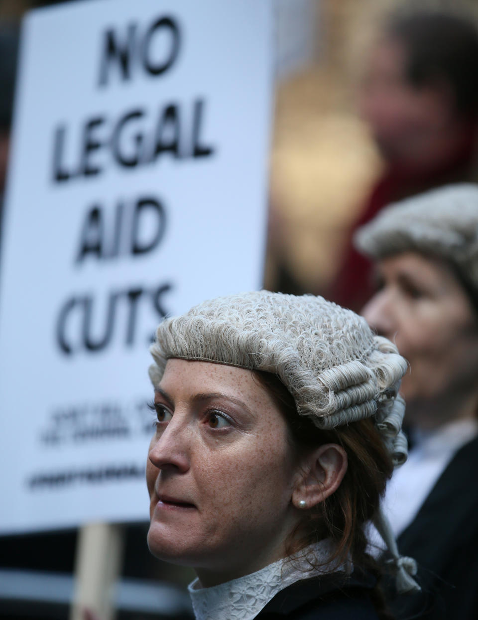 Lawyer Alice Jarratt takes part in a protest outside Southwark Crown Court during a demonstration against cuts to legal aid funding, in London, Monday, Jan. 6, 2014. Hundreds of British lawyers, many dressed in traditional wigs and gowns, have swapped courtrooms for picket lines to protest planned cuts to legal-aid funding. Hearings were disrupted Monday at courts including London’s famous Old Bailey as barristers staged their first-ever national walkout. The British government, which has slashed spending in the name of deficit reduction, plans to cut lawyers’ fees in a bid to reduce the legal aid budget by 220 million pounds ($360 million) by 2019. (AP Photo/Alastair Grant)