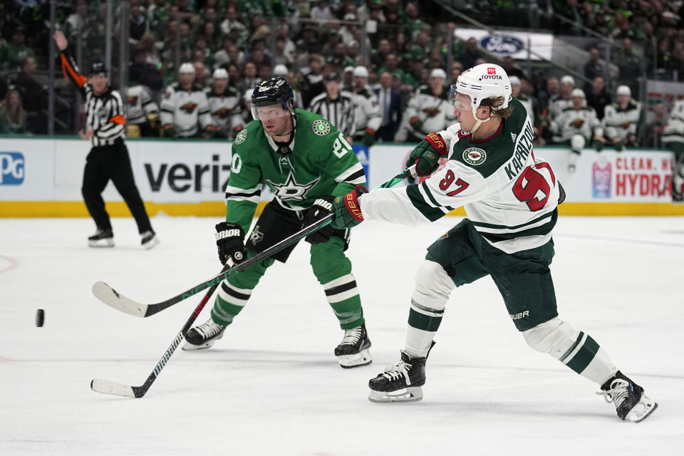 Minnesota Wild left wing Kirill Kaprizov (97) shoots as Dallas Stars' Ryan Suter (20) defends during the second period of Game 5 of an NHL hockey Stanley Cup first-round playoff series, Tuesday, April 25, 2023, in Dallas. (AP Photo/Tony Gutierrez)