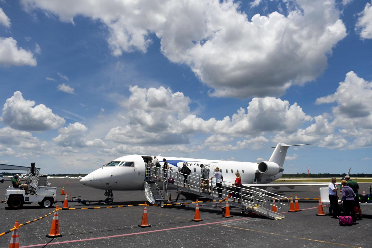 Passengers begin boarding an Elite Airways jet headed for Portland, Maine on Monday, June 3, 2019, on the tarmac at the Vero Beach Regional Airport.
