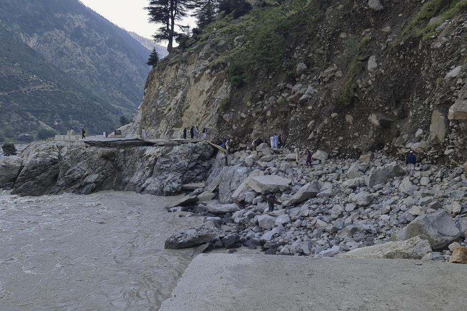 Local residents cross a portion of road destroyed by floodwaters in Kalam Valley in northern Pakistan, Tuesday, Aug. 30, 2022. Officials in Pakistan raised concerns Wednesday over the spread of waterborne diseases among thousands of flood victims as flood waters from powerful monsoon rains began to recede in many parts of the country. (AP Photo/Sherin Zada)