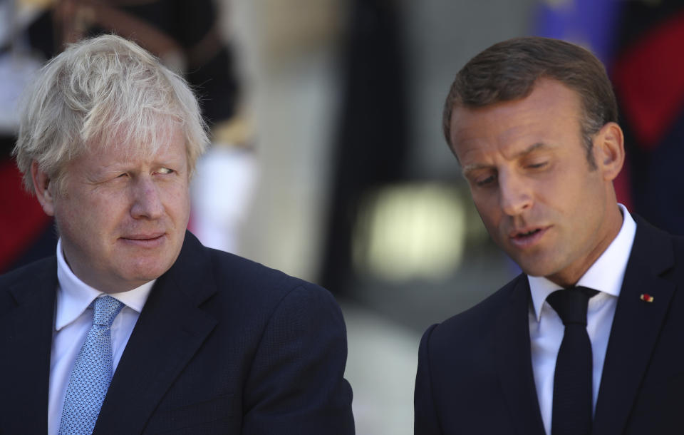 Britain's Prime Minister Boris Johnson looks across at French President Emmanuel Macron at the Elysee Palace, Thursday, Aug. 22, 2019 in Paris. Boris Johnson traveled to Berlin Wednesday to meet with Chancellor Angela Merkel before heading to Paris to meet with French President Emmanuel Macron. (AP Photo/Daniel Cole)