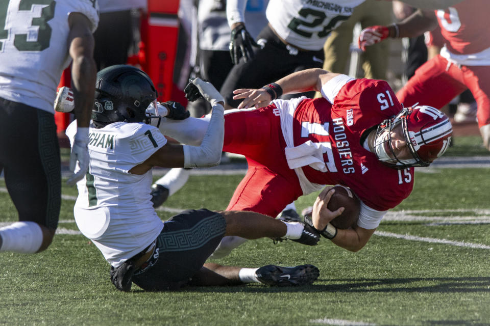 Indiana quarterback Brendan Sorsby (15) is pulled down in the backfield by Michigan State defensive back Jaden Mangham (1) during the second half of an NCAA college football game, Saturday, Nov. 18, 2023, in Bloomington, Ind. (AP Photo/Doug McSchooler)