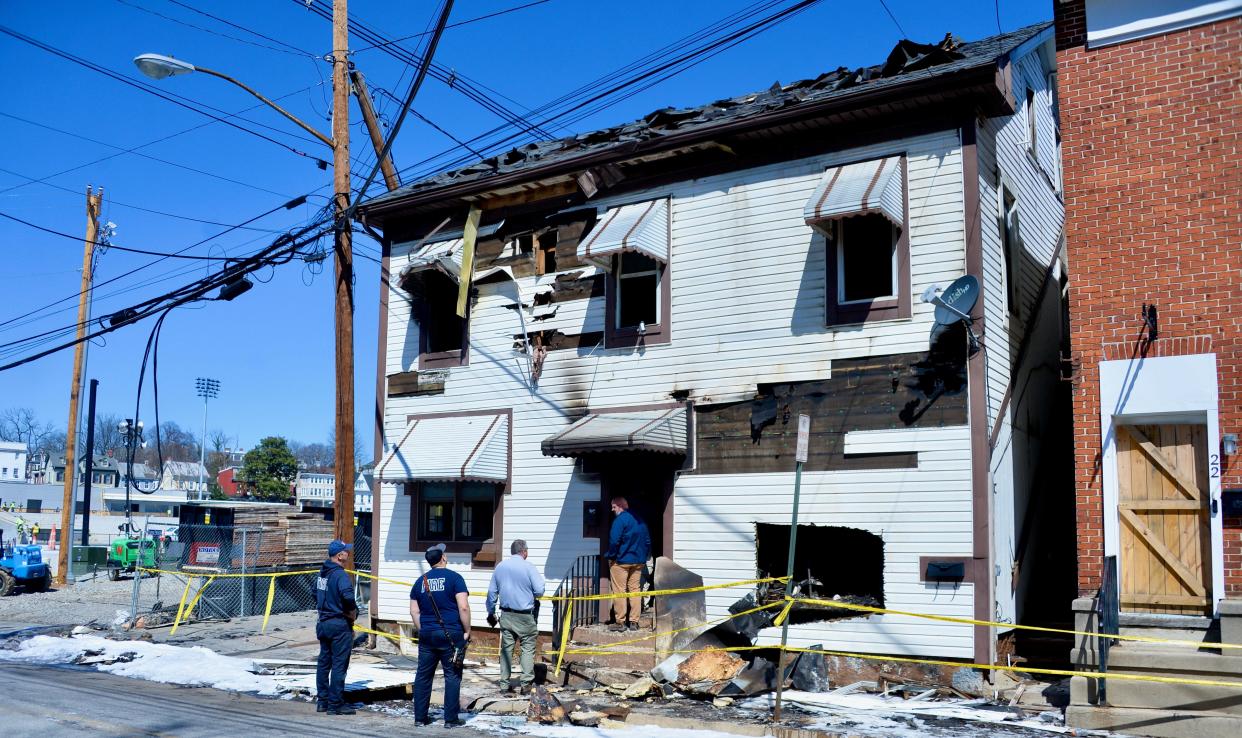 Fire officials, including Hagerstown Fire Marshal Dale Fishack in the blue shirt, check out the building at 24-28 W. Baltimore St., where there was a fire Sunday night.