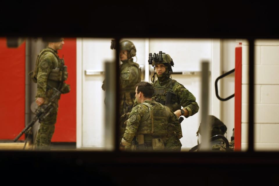 Police officers in tactical gear get ready in the Lisbon High School gymnasium amid active search for gunman (EPA)