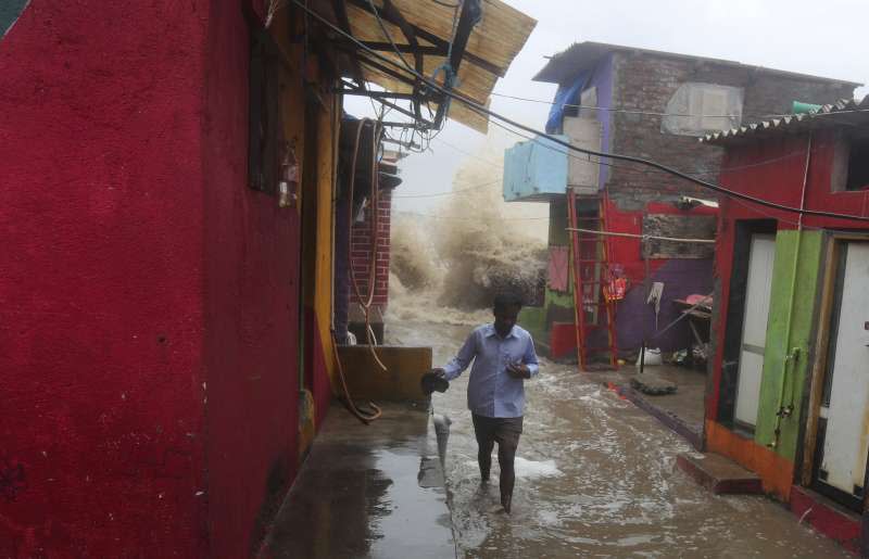 印度雨季導致暴洪，大水正要衝進一處窄巷。（AP）