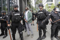 Activist David Lewis, center, walks past police officers as he heads in to Seattle City Hall to meet with the mayor Wednesday, June 3, 2020, in Seattle, following protests over the death of George Floyd, a black man who was in police custody in Minneapolis. (AP Photo/Elaine Thompson)