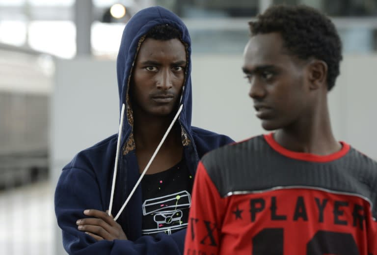 Refugees wait at a first registration point on a platform of the railway station in Rosenheim, southern Germany, on July 29, 2015