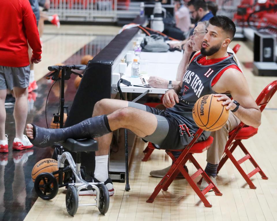 Forward Fardaws Aimaq (11) bounces a ball on the bench while recuperating from an injury during Texas Tech’s first official practice, Sept. 26, 2022, at the United Supermarkets Arena in Lubbock.