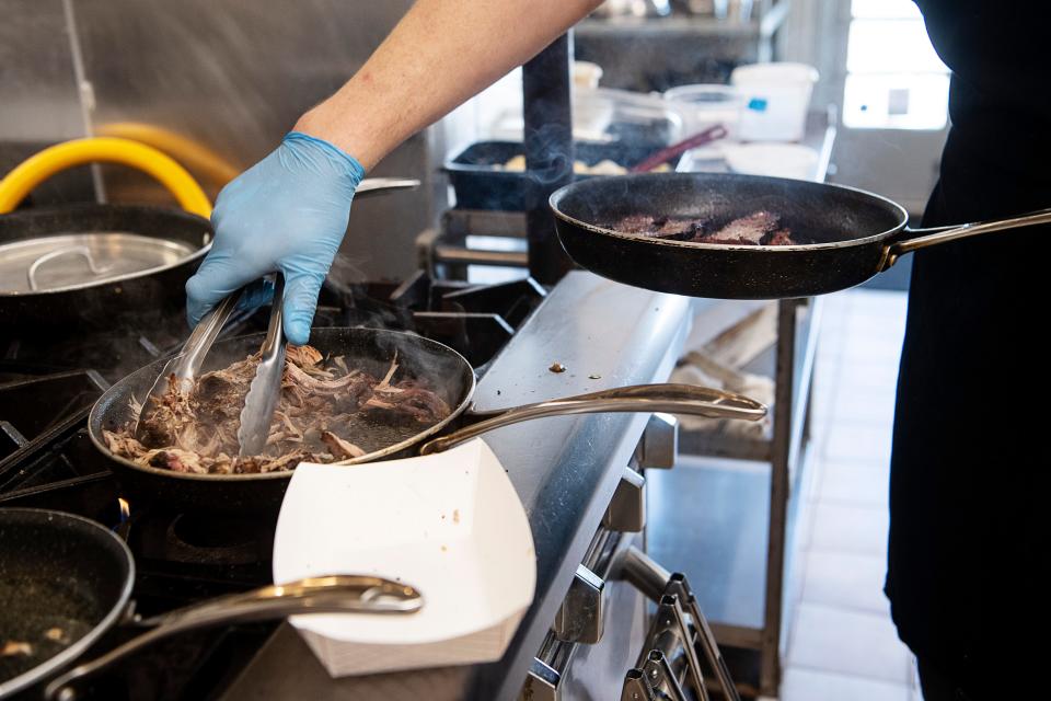 Chef Ben Malone warms up brisket and pulled pork for a to-go order at Smoked! BBQ, October 4, 2023.