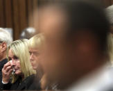 June Steenkamp, the mother of Reeva Steenkamp, left, wipes her face with a tissue at the start the trial of Oscar Pistorius at the high court in Pretoria, South Africa, Monday, March 3, 2014. Pistorius pleaded not guilty Monday to murdering his girlfriend on Valentine's Day last year, marking the start of the Olympian's murder trial that had South Africans watching live broadcasting of the proceedings against their country's most famous living citizen. (AP Photo/Themba Hadebe, Pool)