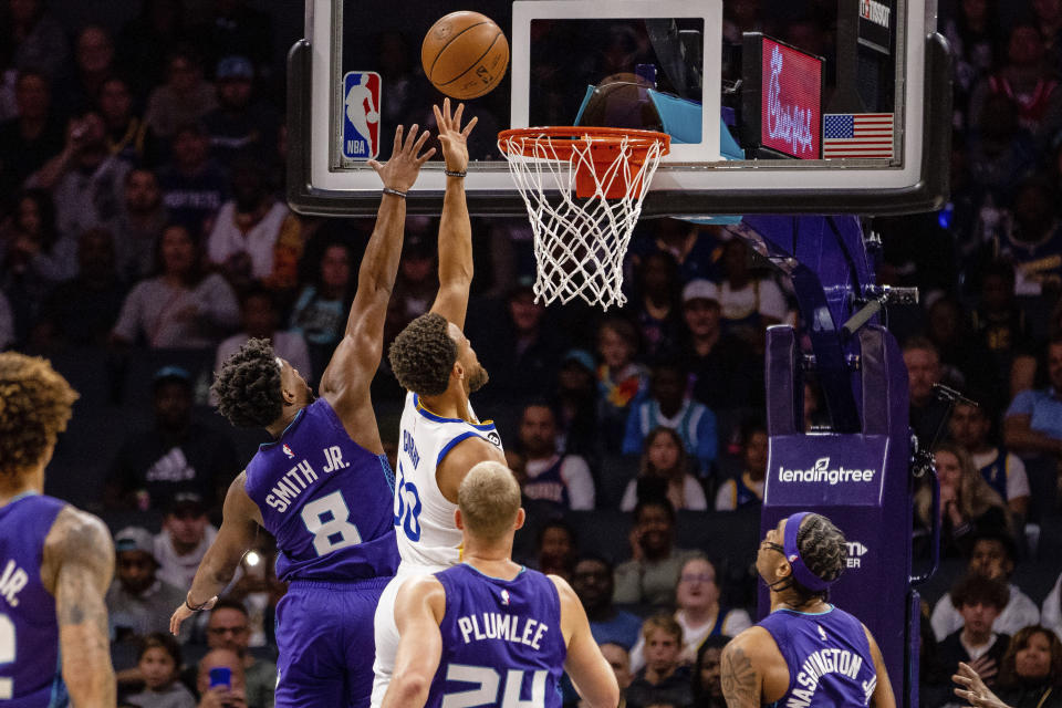 Charlotte Hornets guard Dennis Smith Jr. (8) guards Golden State Warriors guard Stephen Curry (30) during the first half of an NBA basketball game on Saturday, Oct. 29, 2022, in Charlotte, N.C. (AP Photo/Scott Kinser)