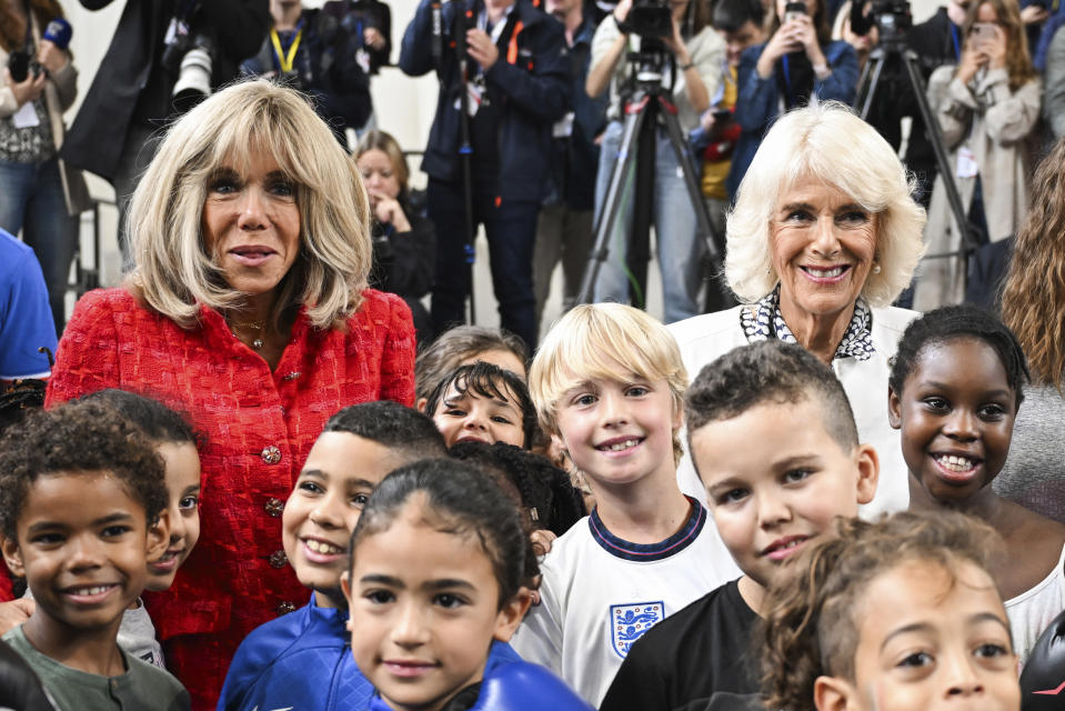 Britain's Queen Camilla, right, poses with French President Emmanuel Macron's wife Brigitte Macron and children during a visit to a gymnasium, Thursday, Sept. 21, 2023 in Saint-Denis, outside Paris. On the second day of his state visit to France, King Charles met with sports groups in the northern suburbs of Paris and was scheduled to pay a visit to fire-damaged Notre-Dame cathedral. (Bertrand Guay, Pool via AP)