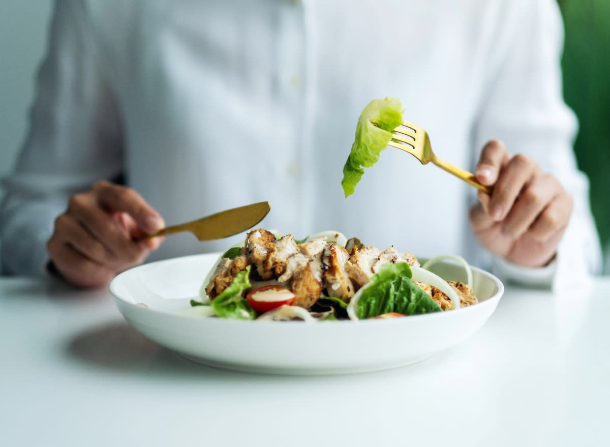 woman eating salad with chicken, concept of food sequencing for weight loss