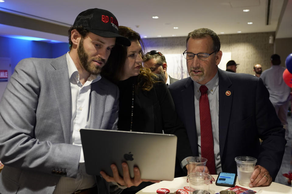 Republican gubernatorial candidate, state Sen. Brian Dahle, right, looks at early election returns with his wife, Assemblywoman Megan Dahle, on a laptop held by Erik Brahms, Megan Dahle's Assembly chief of staff, at an election night gathering in Sacramento, Calif., Tuesday, June 7, 2022. (AP Photo/Rich Pedroncelli)