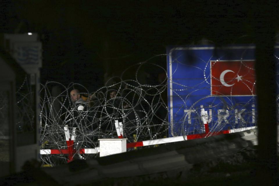 Migrants stand near Kastanies border gate at the Greek-Turkish border, Saturday, Feb. 29, 2020. Turkey's President Recep Tayyip Erdogan said his country's borders with Europe were open Saturday, making good on a longstanding threat to let refugees into the continent as thousands of migrants gathered at the frontier with Greece. (AP Photo/Giannis Papanikos)