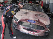 Corey LaJoie leans over the hood of his car with a likeness of him painted on the front end before a practice session for the NASCAR Daytona 500 auto race at Daytona International Speedway, Friday, Feb. 15, 2019, in Daytona Beach, Fla. (AP Photo/John Raoux)