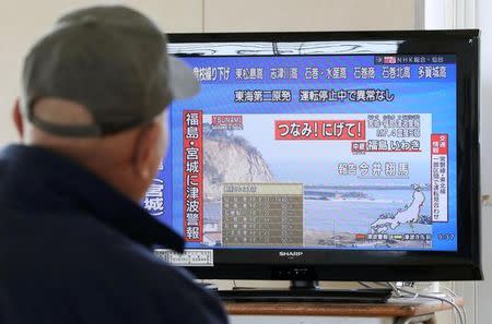 A man evacuated from his home looks at a television screen showing a news report on tsunami warnings, at a shelter following an earthquake, in Sendai, Japan, in this photo taken by Kyodo November 22, 2016. Kyodo/via REUTERS