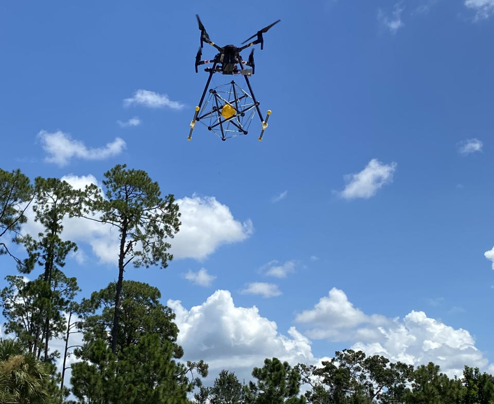 The squishy robot attached to a drone in the sky.