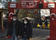 People wearing masks to help protect against the spread of coronavirus, walk along a popular street in Ankara, Turkey, Friday, Nov. 27, 2020. Turkey's COVID-19 fatalities continue to rise, hitting another record Sunday, Nov 29, 2020, with 185 new deaths. The Turkish government resumed reporting all positive cases this week after only reporting symptomatic patients for four months. Night-time curfews over the weekend are in effect for a second week across the country but media reports show packed public spaces during the day. (AP Photo/Burhan Ozbilici)