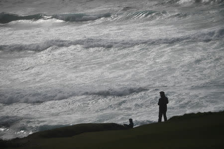 People look out at rough sea from Slea Head during Storm Ali in Coumeenoole, Ireland, September 19, 2018. REUTERS/Clodagh Kilcoyne