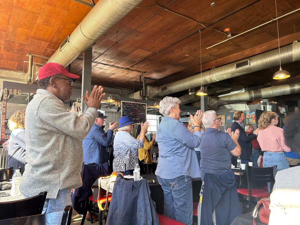 Attendees stand and clap as U.S. Representative Gloria Johnson takes the stage to talk about her Senate campaign platform on November 18, 2022 at Baker Bros BBQ in Jackson, Tenn.