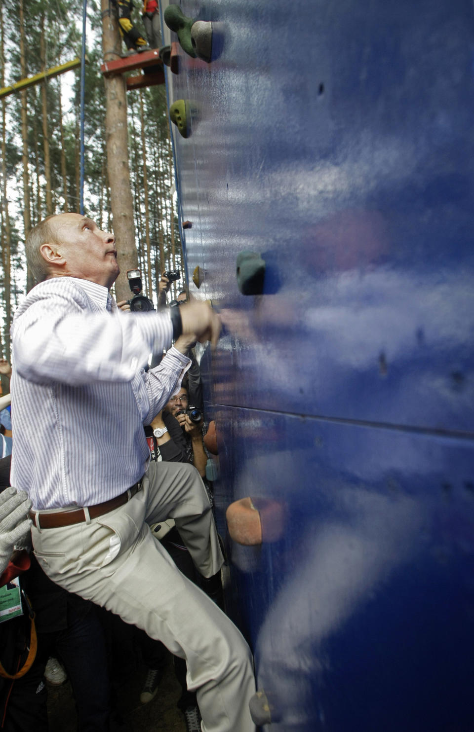 Russian Prime Minister Vladimir Putin scales a climbing wall during his visit at a summer camp run by the Nashi youth group at Lake Seliger in the central Tver region on Aug. 1, 2011.&nbsp;