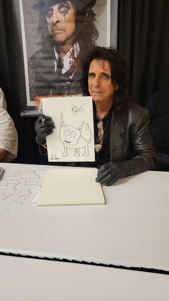 Detroit-born rocker Alice Cooper displays an autographed cat sketch he's donating for Michigan Cat Rescue fundraising.