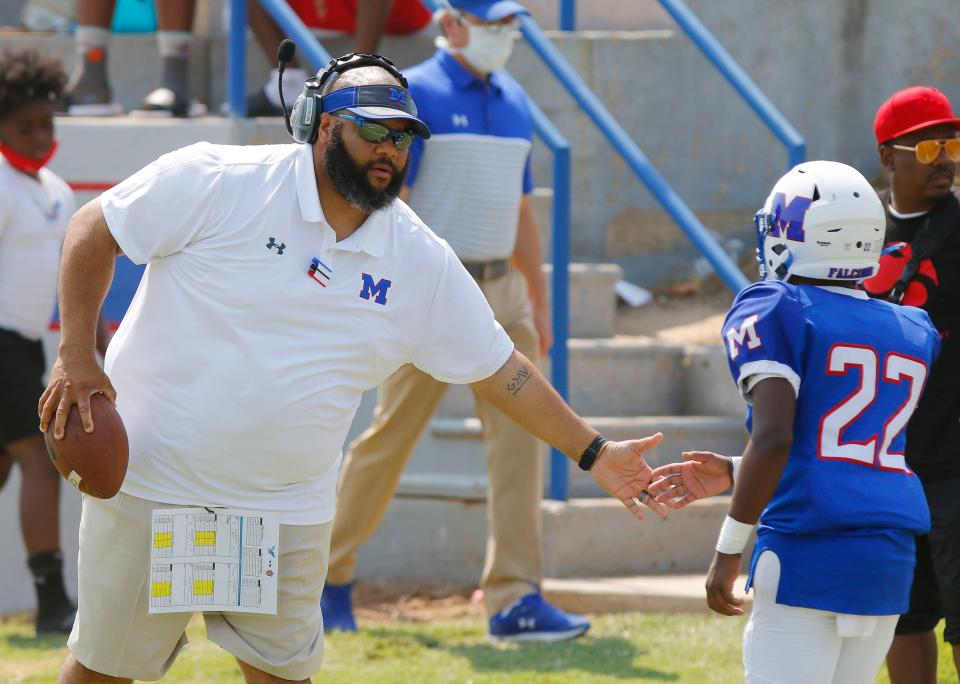 Millwood coach Darwin Franklin encourages DeAunte Shaw (22) as he comes off the field at the Soul Bowl against Douglass on Sept. 11, 2021.