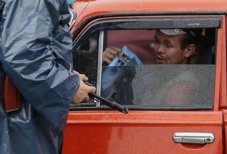 A man shows his documents as he returns to Luhansk, at a checkpoint in Debaltseve, September 9, 2014. REUTERS/Gleb Garanich