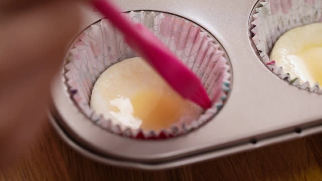 brushing pastry in lined muffin tin with eggwash