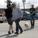 In this Oct. 10, 2013, photo, Mack Eldridge, right, an inmate at Dixon Correctional Institute in Jackson, La., on a work release program, walks a pit bull as Tia Maria Torres (not shown), star of Animal Planet’s “Pit Bulls and Parolees,” films an episode show's fifth season in New Orleans. Torres, who runs the nation’s largest pit bull rescue center and has long paired abused and abandoned dogs with the parolees who care for them, has moved her long-running reality TV series from southern California to New Orleans, where hurricanes and overbreeding have left many pit bulls abandoned or abused. (AP Photo/Gerald Herbert)