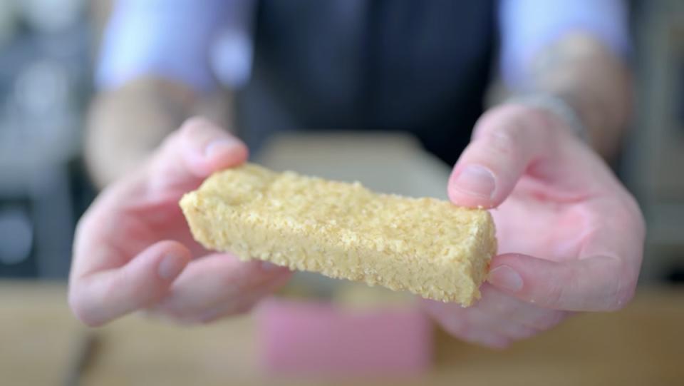 Andrew Rea holds a shortbread cookie up to the camera in his Ted Lasso video