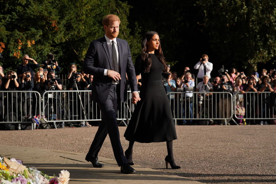 WINDSOR, ENGLAND - SEPTEMBER 10: Prince Harry, Duke of Sussex, and Meghan, Duchess of Sussex view floral tributes left at Windsor Castle on September 10, 2022 in Windsor, England. Crowds have gathered and tributes left at the gates of Windsor Castle to Queen Elizabeth II, who died at Balmoral Castle on 8 September, 2022. (Photo by Kirsty O'Connor - WPA Pool/Getty Images)