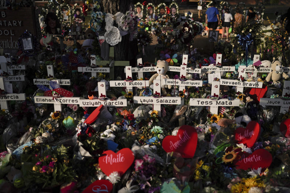 FILE - Flowers are piled around crosses with the names of the victims killed in a school shooting as people visit a memorial at Robb Elementary School to pay their respects May 31, 2022, in Uvalde, Texas. For the first time since the Uvalde school massacre, Texas Republican lawmakers on Tuesday, April 18, 2023, allowed proposals for stricter gun laws to get a hearing in the state Capitol — even though new restrictions have almost no chance of passing. (AP Photo/Jae C. Hong, File)