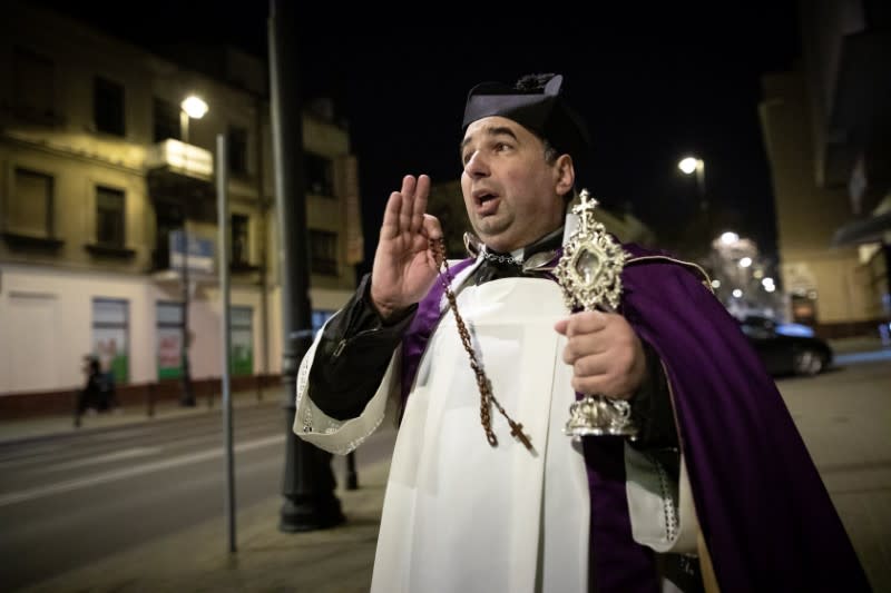 A priest Miroslaw Matuszny walks on the street holding Relics of St Anthony as he prays to stop spread of coronavirus (COVID-19) in Lublin