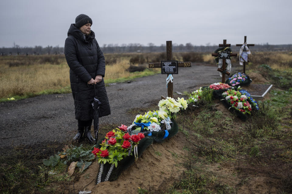 Svetlana Shornik stands next to the grave of her 53-year-old ex-husband, Oleh Shornik, on the outskirts Kherson, Ukraine, on Sunday, Nov. 20, 2022. Oleh Shornik was among 20 civilian volunteers of Ukraine’s Territorial Defense Forces killed by Russian troops in March in the southern city before it fell to Moscow. Russia held it for eight months before retreating in November. (AP Photo/Bernat Armangue)