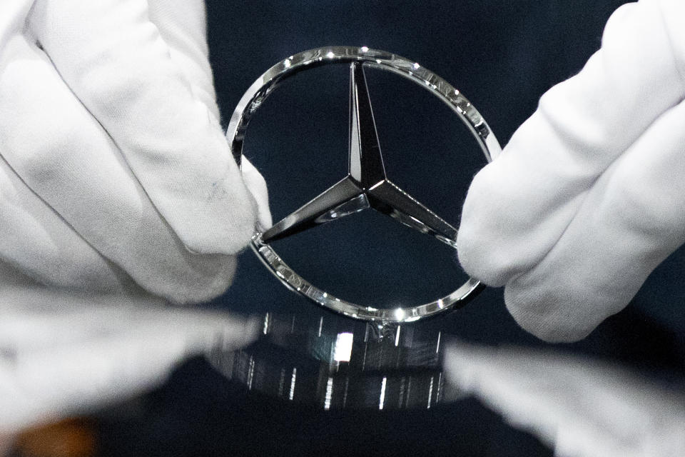 FILE - In this Wednesday, April 3, 2019 file photo, a worker wipes a logo of a car at the Mercedes Benz automobile assembly plant outside Moscow, Russia. German automaker Daimler on Friday dismissed a “cease and desist” demand from two environmental groups to commit to ending the sale of combustion engine vehicles by 2030. Lawyers for Greenpeace and the group Deutsche Umwelthilfe have threatened to sue Daimler, BMW and Volkswagen unless they sign a legal pledge not to put new gas-fueled vehicles onto the market from the end of this decade. (AP Photo/Pavel Golovkin, file)