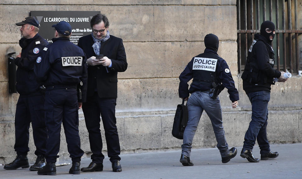 Police officers cordon off the area near the Louvre museum near where a soldier opened fire after he was attacked in Paris, Friday, Feb. 3, 2017. Police say the soldier opened fire outside the Louvre Museum after he was attacked by someone, and the area is being evacuated. (AP Photo/Christophe Ena)