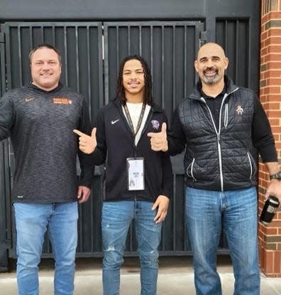Idabel High School football player Matrail Lopez, center, committed to Oklahoma State after a campus visit where he met with offensive coordinator Kasey Dunn, right, and running backs coach John Wozniak.