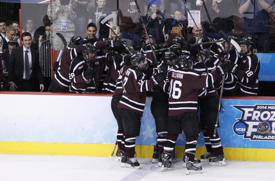 Union celebrates on the bench following an empty-net goal by Mat Bodie, front right, during the third period of an NCAA men's college hockey Frozen Four tournament game against Minnesota, Saturday, April 12, 2014, in Philadelphia. Union won 7-4. (AP Photo/Chris Szagola)