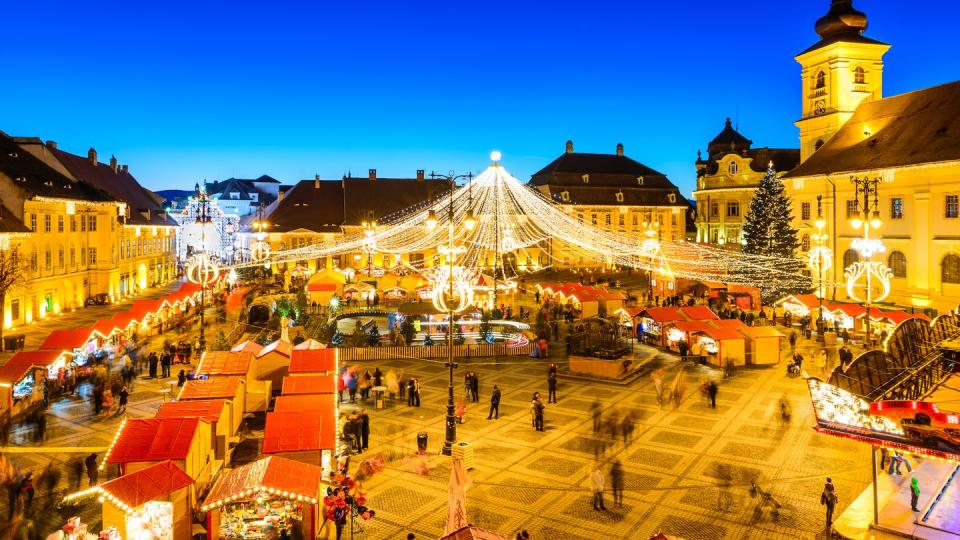 sibiu, romania 20 december 2014 night image with tourists at christmas market in great market of medieval sibiu, transylvania landmark