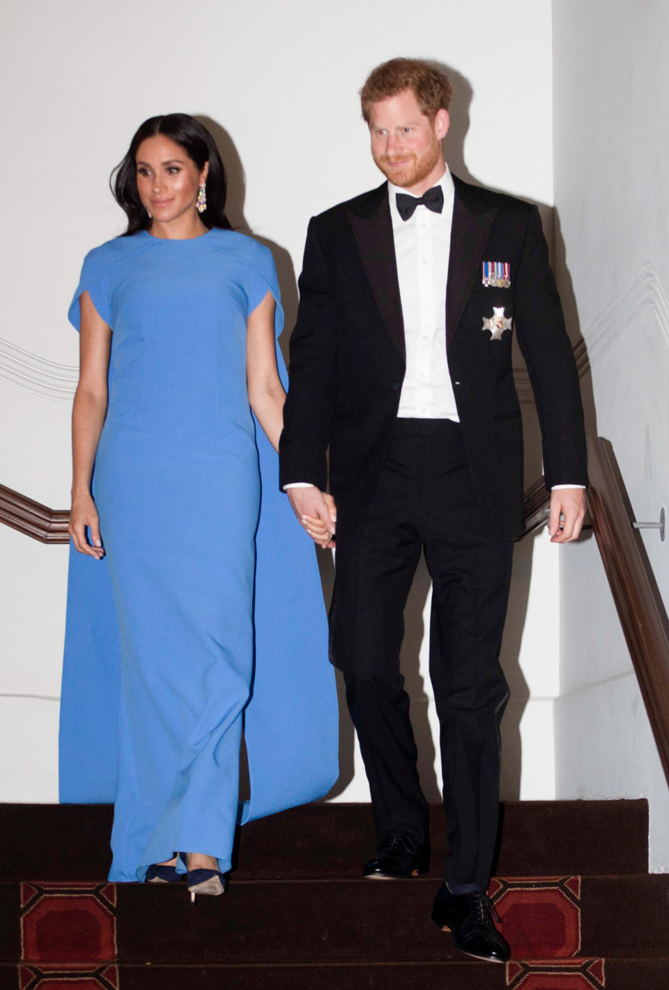 Meghan Markle dressed in a floor length, caped gown by London-based label SAFiyAA for a state dinner in Fiji. Photo: Getty Images