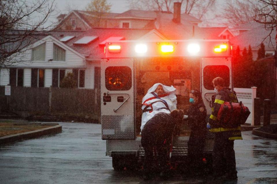 Medics load a patient into the ambulance at the West Revere Health Center in Revere, Massachusetts.