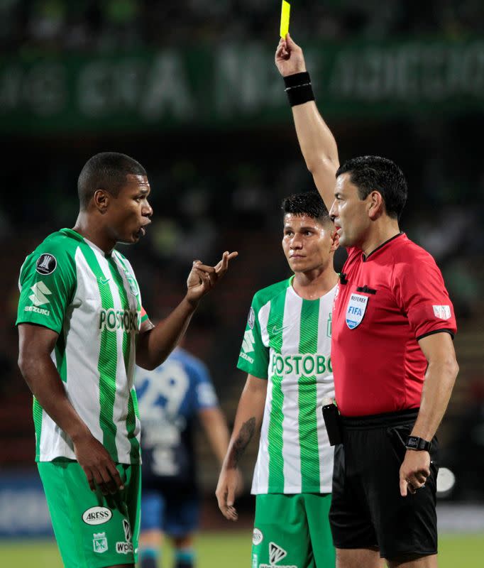 Foto de archivo. Un jugador del club colombiano Atlético Nacional recibe tarjeta amarilla en un partido contra Atlético Tucumán de Argentina por la Copa Libertadores de América, en el estadio Atanasio Girardot de Medellín