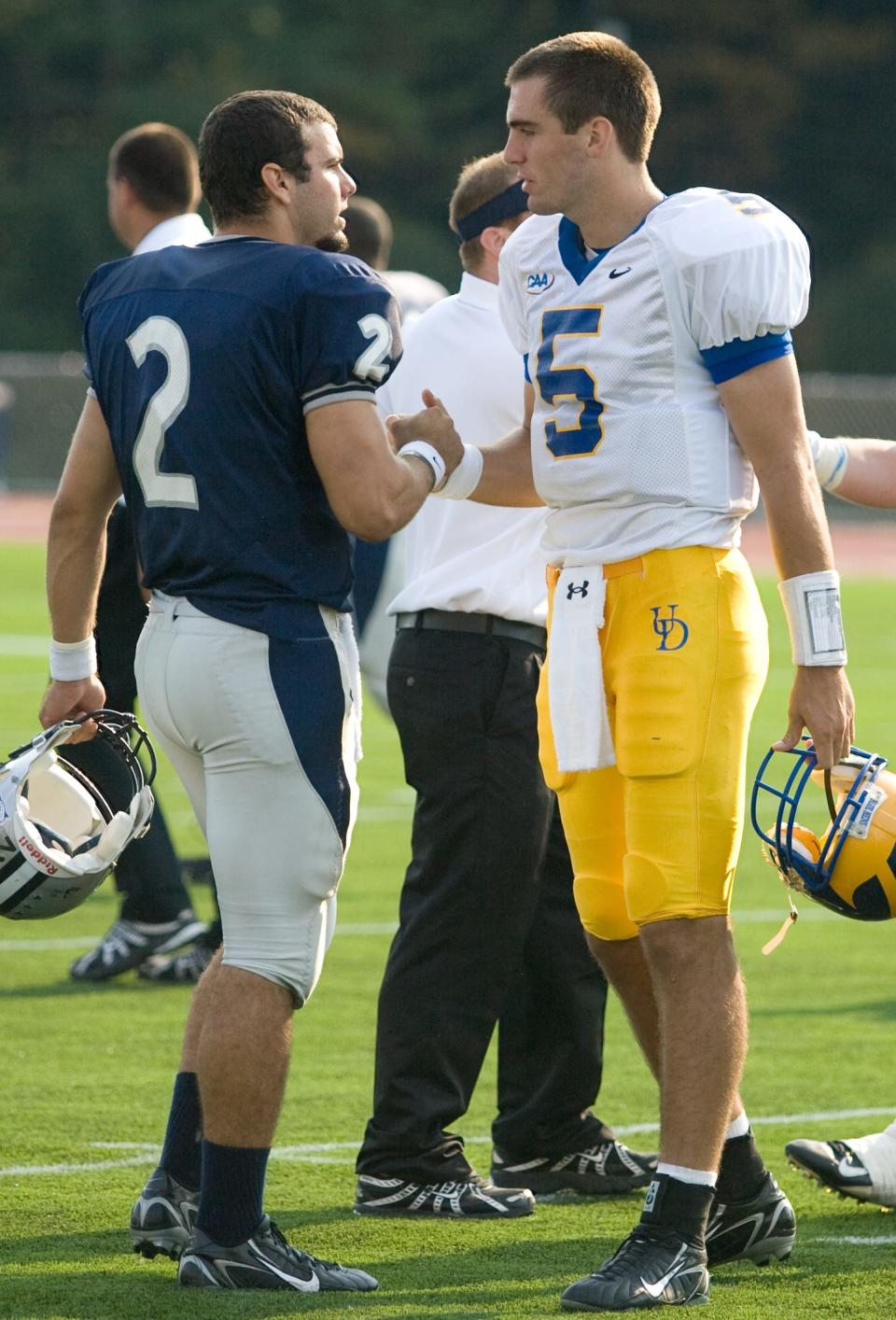 Former New Hampshire quarterback Ricky Santos (left) and former Delaware quarterback Joe Flacco greet each other after a college football game in 2007.