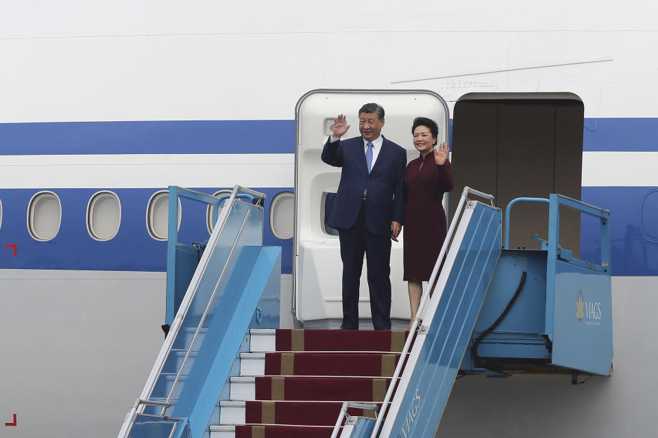 Chinese President Xi Jinping, left, and his wife Peng Liyuan, right, wave as they arrive at Noi Bai International airport in Hanoi, Vietnam, Tuesday, Dec. 12, 2023. Chinese leader Xi arrived in Vietnam on Tuesday seeking to further deepen ties with the Southeast Asian nation, weeks after it elevated its diplomatic relations with Western-aligned countries. (Luong Thai Linh/Pool Photo via AP)