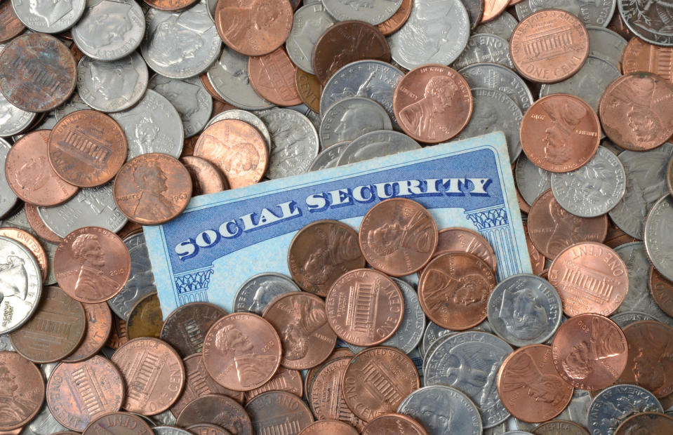 Social Security card folded into a pile of coins.